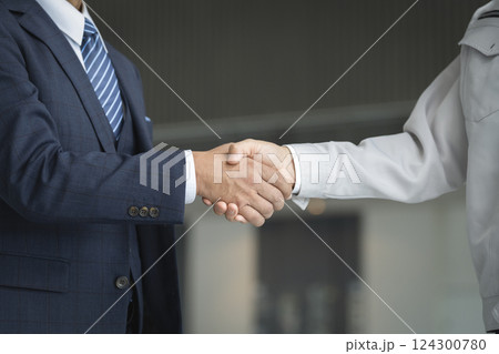 ビジネスイメージ 握手をするスーツのビジネスマンと作業服の男性の手元 ビジネスイメージ 握手をするスーツのビジネスマンと作業服の男性の手元 124300780
