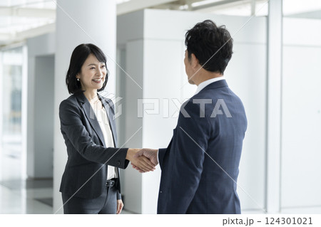 握手をする男女のビジネスパーソン 握手をする男女のビジネスパーソン 124301021