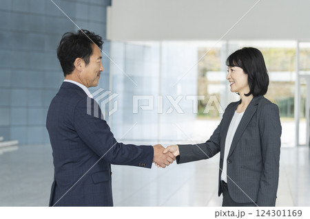 握手をする男女のビジネスパーソン 握手をする男女のビジネスパーソン 124301169