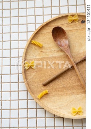 time to eat pasta. wooden plate with fork and spoon in form of clock hands. pasta on plate. time to eat pasta. wooden plate with fork and spoon in form of clock hands. pasta on plate. 124301431