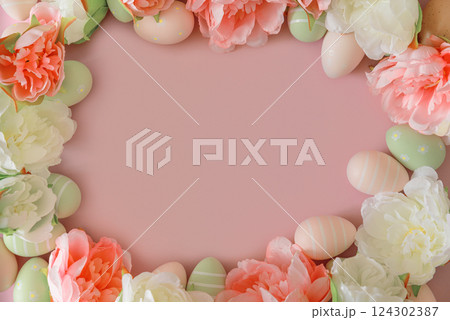Easter eggs and spring flowers on pastel background. Top view 124302387
