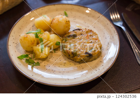 Squash burger with boiled potatoes on a plate 124302536