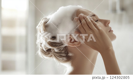 woman washing her hair with foamy shampoo, enjoying relaxing moment 124302805