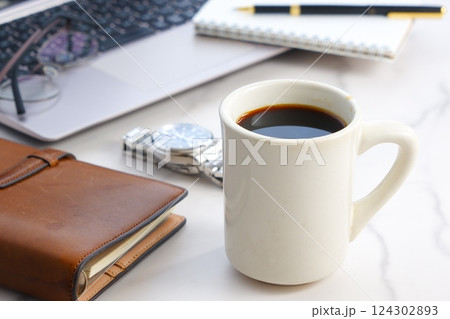 ノートパソコンでデスクワークの合間に、淹れたてのコーヒーでコーヒーブレイクを楽しんでいるイメージ ノートパソコンでデスクワークの合間に、淹れたてのコーヒーでコーヒーブレイクを楽しんでいるイメージ 124302893