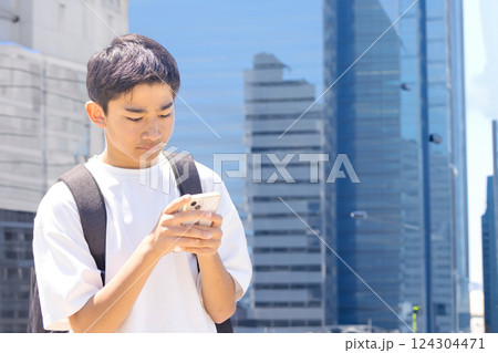 ビジネス街でスマホを見る学生 124304471