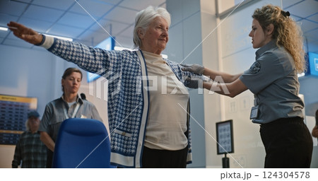 Security Checkpoint: Female TSA Officer Checking Elderly Woman Getting Up from Wheelchair Security Checkpoint: Female TSA Officer Checking Elderly Woman Getting Up from Wheelchair 124304578