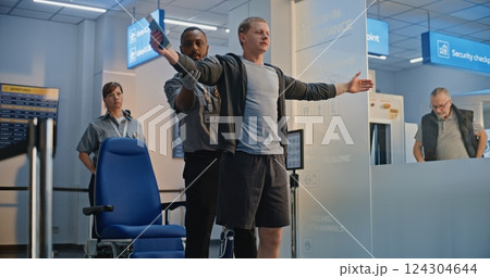 TSA Officer Checking Man with Bionic Prosthetic Leg in Wheelchair in Airport Terminal 124304644