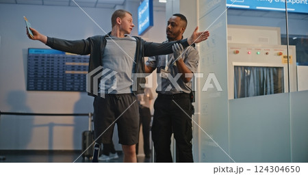 TSA Officer Checking Young Man with Prosthetic Leg in Airport Terminal 124304650
