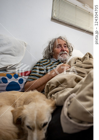Elderly man resting on a sofa with his cute dog 124304705