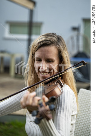 Young woman playing the violin outdoors Young woman playing the violin outdoors 124304708