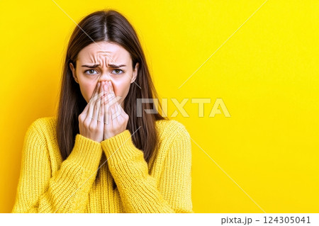 Emotional Expression of a Disgusted Woman Against Yellow Background 124305041