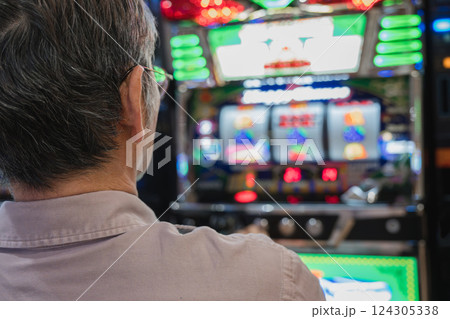 スロットマシンを遊戯する男性 124305338