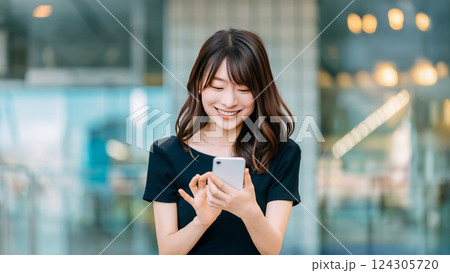 スマートフォンを使う笑顔の女性 124305720