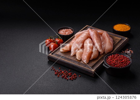 Raw chicken fillet cut into strips with spices and herbs Raw chicken fillet cut into strips with spices and herbs 124305876