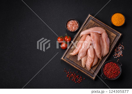 Raw chicken fillet cut into strips with spices and herbs Raw chicken fillet cut into strips with spices and herbs 124305877