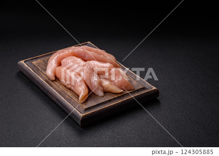 Raw chicken fillet cut into strips with spices and herbs 124305885