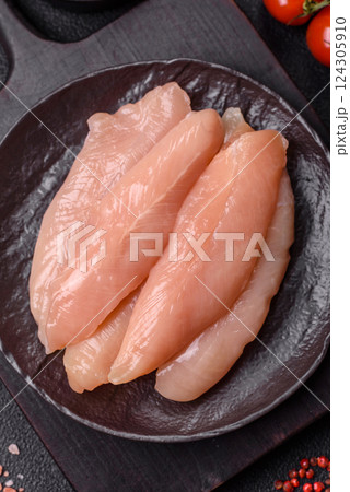 Raw chicken fillet cut into strips with spices and herbs Raw chicken fillet cut into strips with spices and herbs 124305910