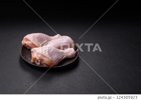 Raw chicken legs with salt, spices and herbs 124305923