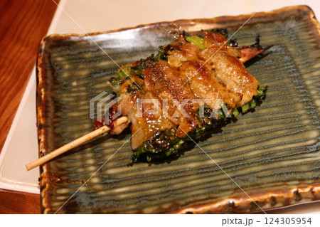 close up of grilled chive wrapped with pork roll skewer on a plate close up of grilled chive wrapped with pork roll skewer on a plate 124305954