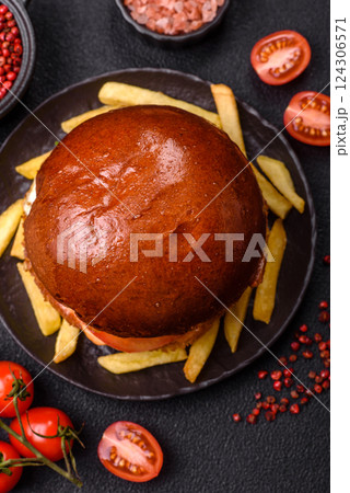Delicious burger with beef patty, fried egg, bacon, herbs, sauce, salt and spices 124306571