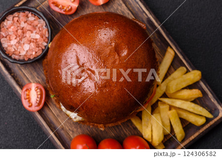 Delicious burger with beef patty, fried egg, bacon, herbs, sauce, salt and spices 124306582