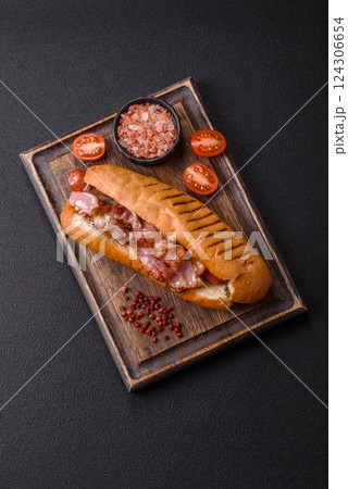 Delicious juicy hot dog with sausage, bacon, sauce, salt and spices 124306654