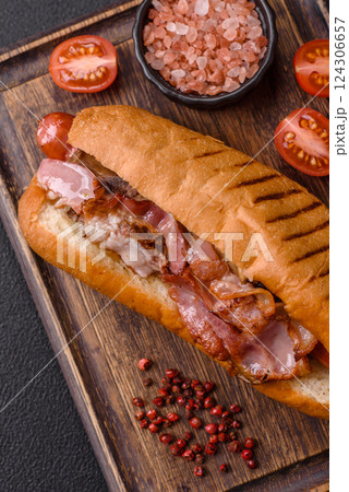 Delicious juicy hot dog with sausage, bacon, sauce, salt and spices 124306657
