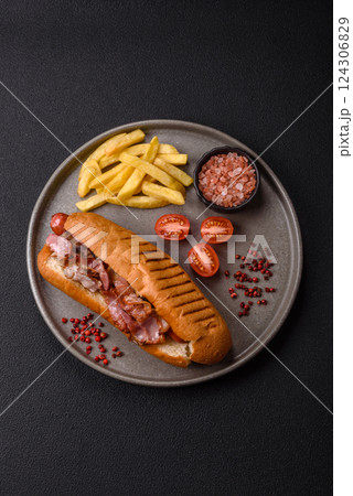 Delicious juicy hot dog with sausage, bacon, sauce, salt and spices 124306829