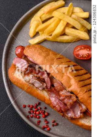 Delicious juicy hot dog with sausage, bacon, sauce, salt and spices 124306832