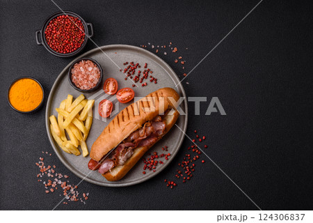 Delicious juicy hot dog with sausage, bacon, sauce, salt and spices 124306837
