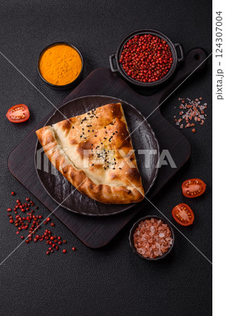 Cheburek meat pastry pie with herbs on the concrete background 124307004