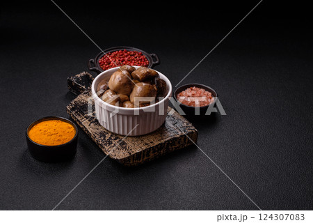 Grilled champignon mushrooms with salt, spices and herbs 124307083