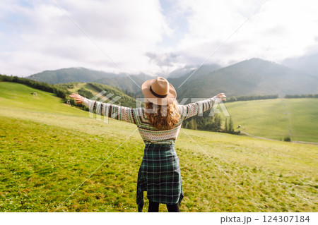 Young woman is having fun, walking through valley with stunning natural panorama. Adventure concept. 124307184