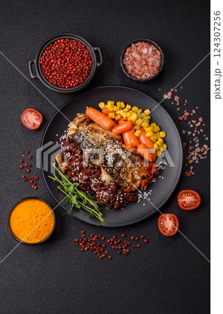 Grilled mackerel fillet pieces with vegetables, salt and spices 124307256