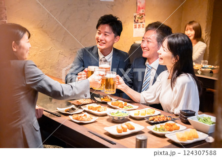 居酒屋で部署のお疲れ様会をするビジネスパーソン 124307588