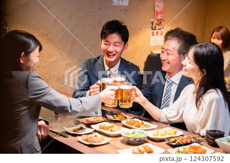 居酒屋で部署のお疲れ様会をするビジネスパーソン 124307592