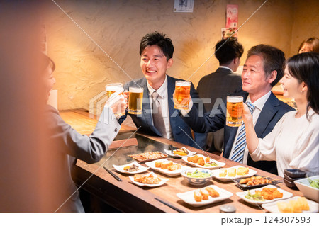 居酒屋で部署のお疲れ様会をするビジネスパーソン 124307593