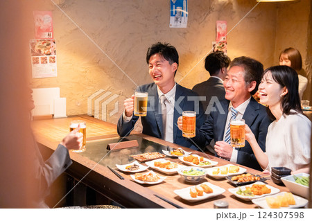 居酒屋で部署のお疲れ様会をするビジネスパーソン 124307598