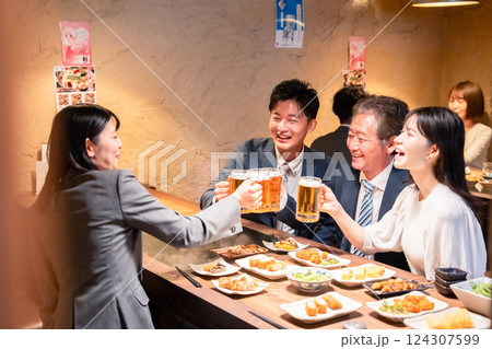 居酒屋で部署のお疲れ様会をするビジネスパーソン 124307599
