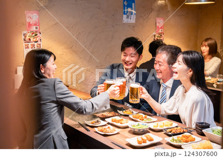 居酒屋で部署のお疲れ様会をするビジネスパーソン 124307600