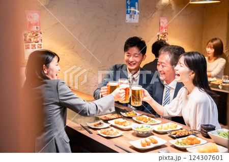 居酒屋で部署のお疲れ様会をするビジネスパーソン 124307601
