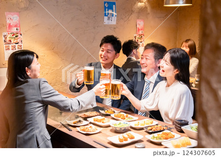居酒屋で部署のお疲れ様会をするビジネスパーソン 124307605