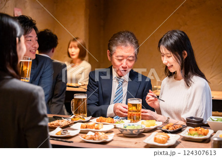居酒屋で部署のお疲れ様会をするビジネスパーソン 124307613