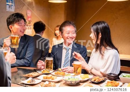 居酒屋で部署のお疲れ様会をするビジネスパーソン 124307616