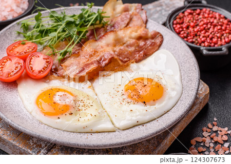 A hearty breakfast with fried eggs, bacon, tomatoes, microgreens A hearty breakfast with fried eggs, bacon, tomatoes, microgreens 124307673