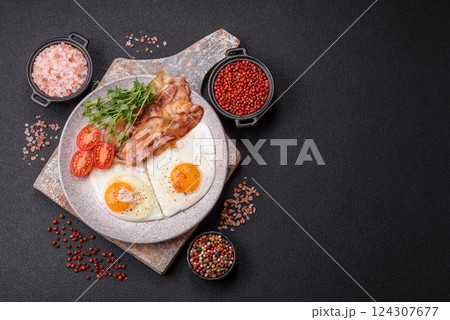 A hearty breakfast with fried eggs, bacon, tomatoes, microgreens 124307677