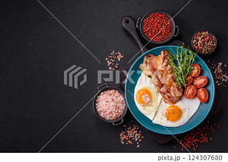 A hearty breakfast with fried eggs, bacon, tomatoes, microgreens A hearty breakfast with fried eggs, bacon, tomatoes, microgreens 124307680