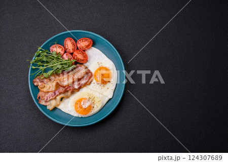 A hearty breakfast with fried eggs, bacon, tomatoes, microgreens A hearty breakfast with fried eggs, bacon, tomatoes, microgreens 124307689