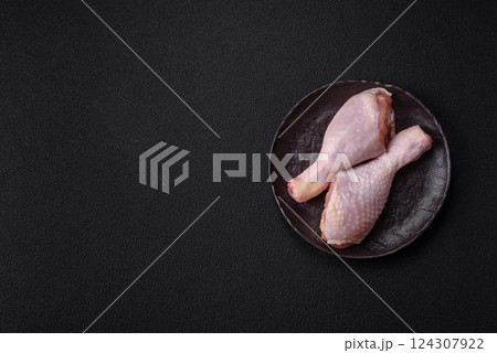 Raw chicken legs with salt, spices and herbs 124307922