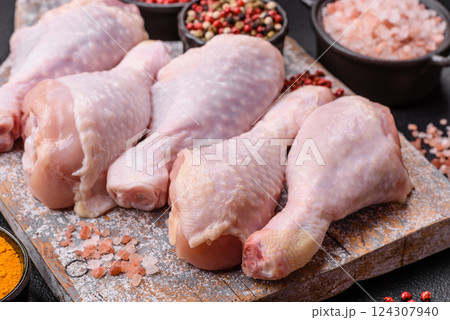 Raw chicken legs with salt, spices and herbs 124307940
